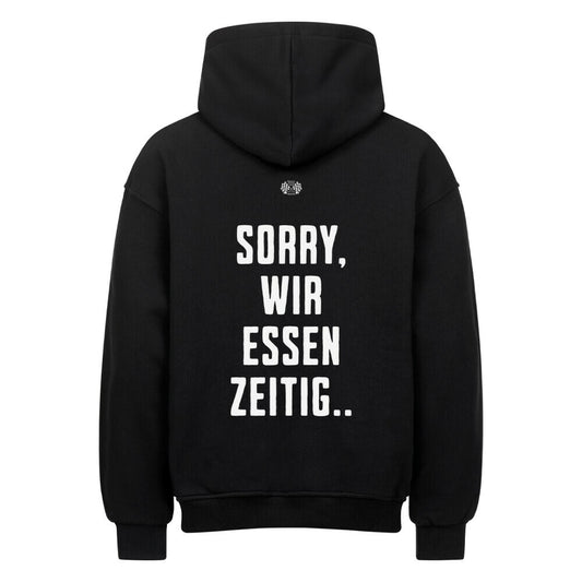 Schwarzer Oversized Hoodie mit großem Rückenprint „Sorry, wir essen zeitig“ im kontrastreichen Mazares Racing Design.